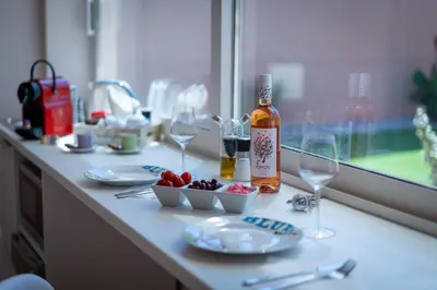 a table with a bottle of wine and glasses on it at Modular Bungalows With Heated Pool Artemis Greece in Artemida