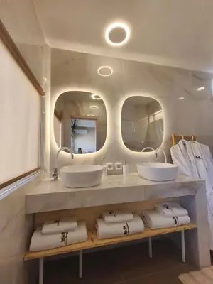 a bathroom with two sinks and two mirrors at Modular Bungalows With Heated Pool Artemis Greece in Artemida