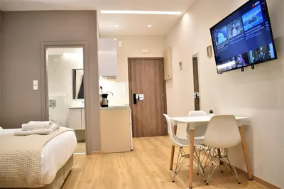a bedroom with a bed and a table and a tv on the wall at Mood Athens Luxury Apartments and Suites in Athens