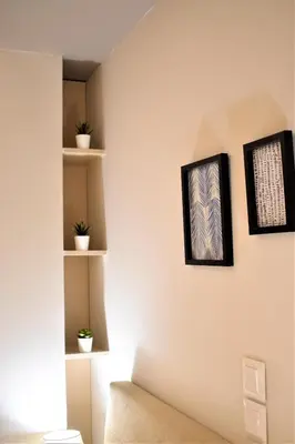 a living room with white walls and shelves at Mood Athens Luxury Apartments and Suites in Athens
