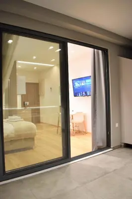 a sliding glass window in a room with a bedroom at Mood Athens Luxury Apartments and Suites in Athens