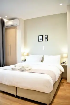a bedroom with a large white bed with white pillows at Mood Athens Luxury Apartments and Suites in Athens