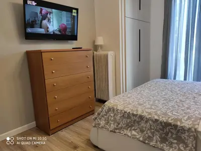 a bedroom with a dresser and a tv on the wall at Studio in Kallithea next to Kiprou square in Athens