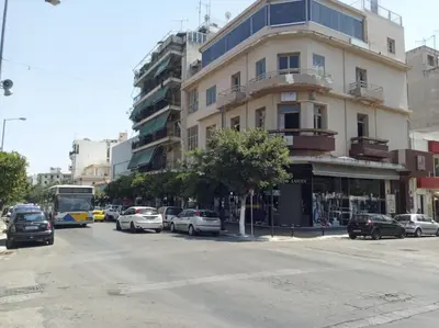 a street with cars parked in front of a building at Studio in Kallithea next to Kiprou square in Athens