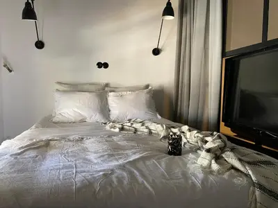 a bedroom with a white bed with a tv at WYN Comfort Studio in Kallithea Near SNFCC and Seasi in Athens