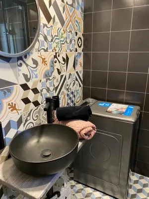 a bathroom with a sink next to a washing machine at WYN Comfort Studio in Kallithea Near SNFCC and Seasi in Athens
