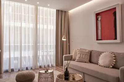 a living room with a couch and two tables at Charitos Boutique Apartment, Kolonaki in Athens