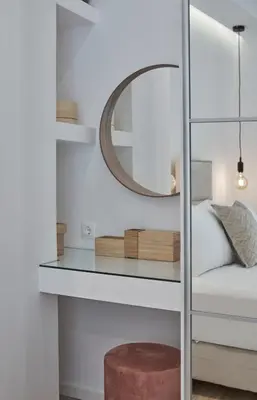 a mirror on a glass shelf next to a bed at Charitos Boutique Apartment, Kolonaki in Athens