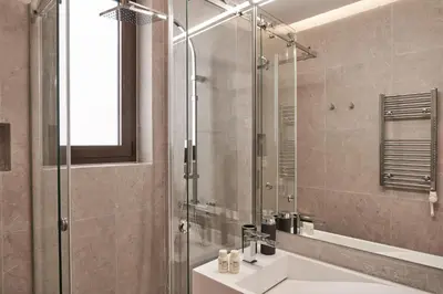 a bathroom with a glass shower and a sink at Charitos Boutique Apartment, Kolonaki in Athens