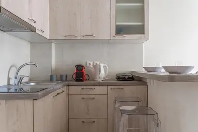 a kitchen with wooden cabinets and a sink at Elvita Apartments 3 in Athens