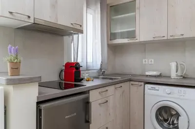 a kitchen with a sink and a washing machine at Elvita Apartments 3 in Athens