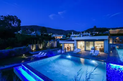 a villa with a swimming pool at night at Black Diamond Luxury Beachfront Villa Selenia in Sounio