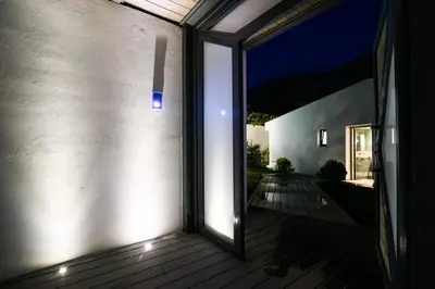 a sliding glass door to a patio at night at Black Diamond Luxury Beachfront Villa Selenia in Sounio
