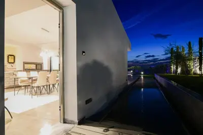 a house with a swimming pool at night at Black Diamond Luxury Beachfront Villa Selenia in Sounio
