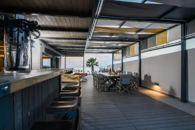 a bar on the roof of a building with a table and chairs at Black Diamond Luxury Beachfront Villa Selenia in Sounio