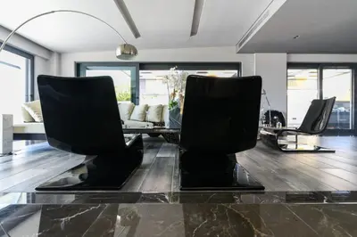 a living room with black chairs and a glass table at Black Diamond Luxury Beachfront Villa Selenia in Sounio