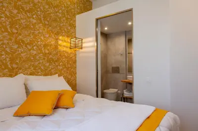 a bedroom with a white bed with yellow pillows at STAY INN in Athens