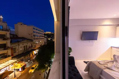 a balcony with a view of a city at night at AcroView Right In The Center in Athens