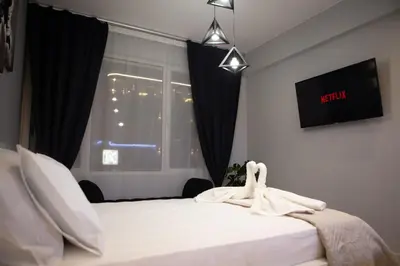a bedroom with a bed with white sheets and a window at AcroView Right In The Center in Athens