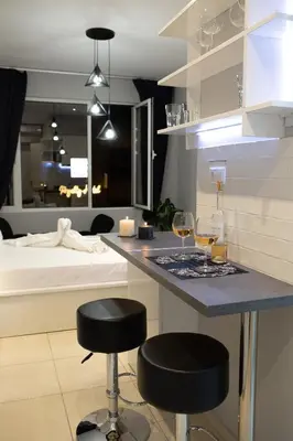 a kitchen with two glasses of wine and two bar stools at AcroView Right In The Center in Athens