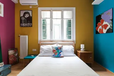 a bedroom with a bed and a window at Mid century 3 bdr city centre townhouse in Athens