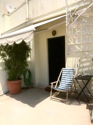 a blue chair sitting in front of a building at Mid century 3 bdr city centre townhouse in Athens