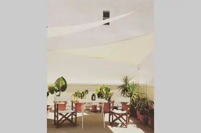 a dining room with tables and chairs and potted plants at Mid century 3 bdr city centre townhouse in Athens