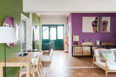 a dining room with a table and purple walls at Mid century 3 bdr city centre townhouse in Athens