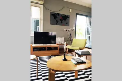 a living room with a coffee table and a television at Mid century 3 bdr city centre townhouse in Athens