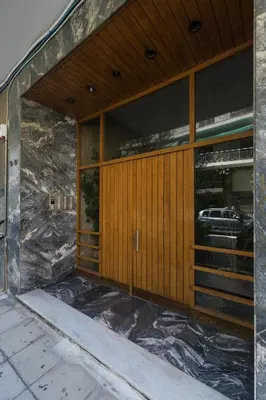 a front door of a building with a car in the window at Serene 1 BR Apartment in Koukaki by UPSTREET in Athens