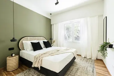 a bedroom with a large bed in a room with a window at Serene 1 BR Apartment in Koukaki by UPSTREET in Athens