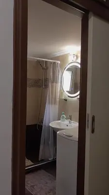 a bathroom with a sink and a shower with a mirror at Ellada Apartment in Athens