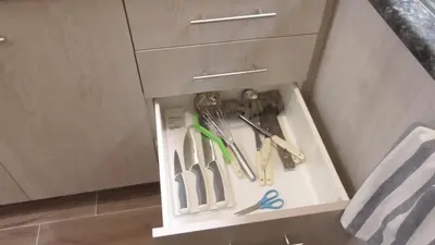 a drawer in a cabinet filled with cutting utensils at Ellada Apartment in Athens