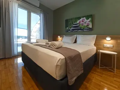 a large bed in a room with a large window at Athens Sweet Home by YHA in Athens