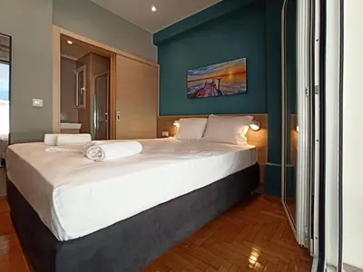 a bedroom with a large bed with a blue wall at Athens Sweet Home by YHA in Athens