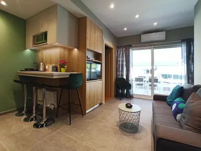 a living room with a couch and a kitchen with a counter at Athens Sweet Home by YHA in Athens