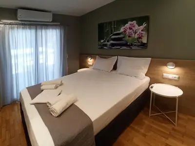 a bedroom with a large white bed with a stool at Athens Sweet Home by YHA in Athens