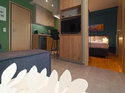 a living room with a bed and a television in a room at Athens Sweet Home by YHA in Athens
