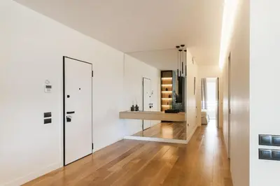 a hallway with white walls and wood floors and a mirror at 5BD 2 Level Beachfront Luxury Apt by the Olon in Athens