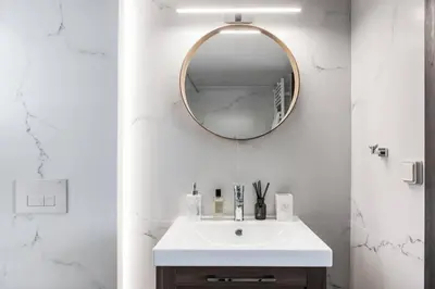 a white bathroom with a sink and a mirror at 5BD 2 Level Beachfront Luxury Apt by the Olon in Athens
