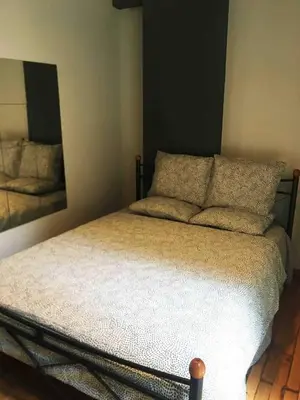a bed in a bedroom with a mirror on the wall at Eleni's Central DownTown Quitness in Athens