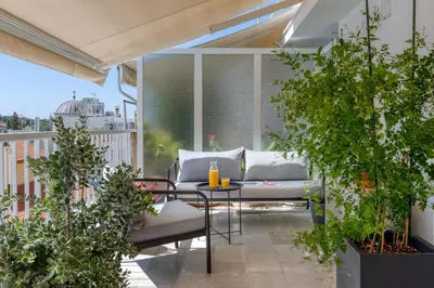 a patio with a table and chairs on a balcony at Central Athens Penthouse in Athens