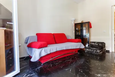a couch with red pillows in a living room at Peonios Apartment in Athens