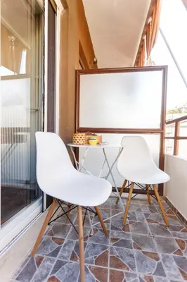 two white chairs and a table in a room with a window at Peonios Apartment in Athens