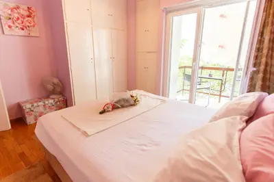a bedroom with a white bed with a window at Peonios Apartment in Athens