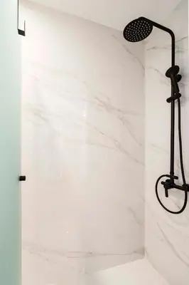 a shower with white marble walls and a black light fixture at Athens' Best Location- Stunning & Spacious Studio in Athens