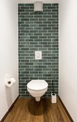 a bathroom with a toilet and a green tiled wall at Athens' Best Location- Unique Magnificent Studio in Athens