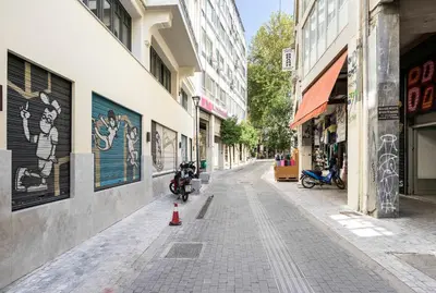 an empty city street with a motorcycle parked on the sidewalk at Athens' Best Location- Unique Magnificent Studio in Athens