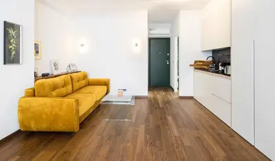 a living room with a yellow couch and a kitchen at Athens' Best Location- Unique Magnificent Studio in Athens