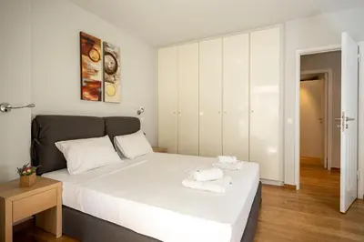 a bedroom with a large white bed with towels on it at AthensBlues Kolonaki 2 Bedroom with Car Park in Athens